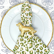 Load image into Gallery viewer, A napkin ring featuring a golden retriever design, placed on a napkin with a leopard print, on a plate with a floral pattern.