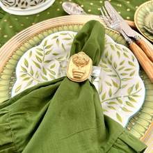 Load image into Gallery viewer, Green table setting with a napkin ring, cutlery, and decorative plates on a green tablecloth.