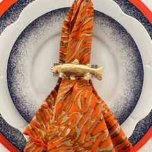 Load image into Gallery viewer, Decorative napkin with a gold fish holder on a white plate with blue rim