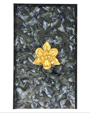 Load image into Gallery viewer, Decorative panel with a gold flower emblem on a textured black background