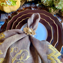 Load image into Gallery viewer, Decorative table setting with brown plates, gold-rimmed white plate, and embroidered napkin.
