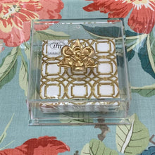 Load image into Gallery viewer, Decorative glass box with gold emblem on a floral background
