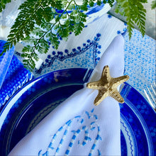 Load image into Gallery viewer, Decorative table setting with blue and white plates, napkin, and starfish.
