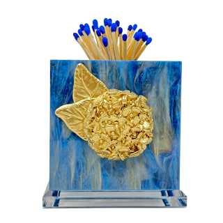 Matches with blue tips in a decorative holder with a gold leaf design on a blue background