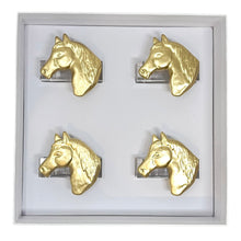 Load image into Gallery viewer, Set of four gold horse head napkin rings in a display case.
