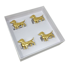Load image into Gallery viewer, Set of gold dog-shaped napkin rings in a box on a white background
