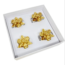 Load image into Gallery viewer, Set of gold flower-shaped napkin rings in a white box
