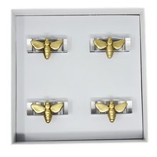 Load image into Gallery viewer, Set of gold bee-shaped napkin rings in a box on a white background
