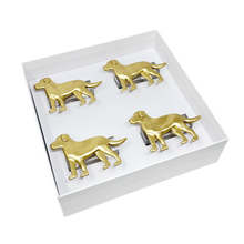 Load image into Gallery viewer, Four gold dog-shaped napkin rings in a white box on a white background
